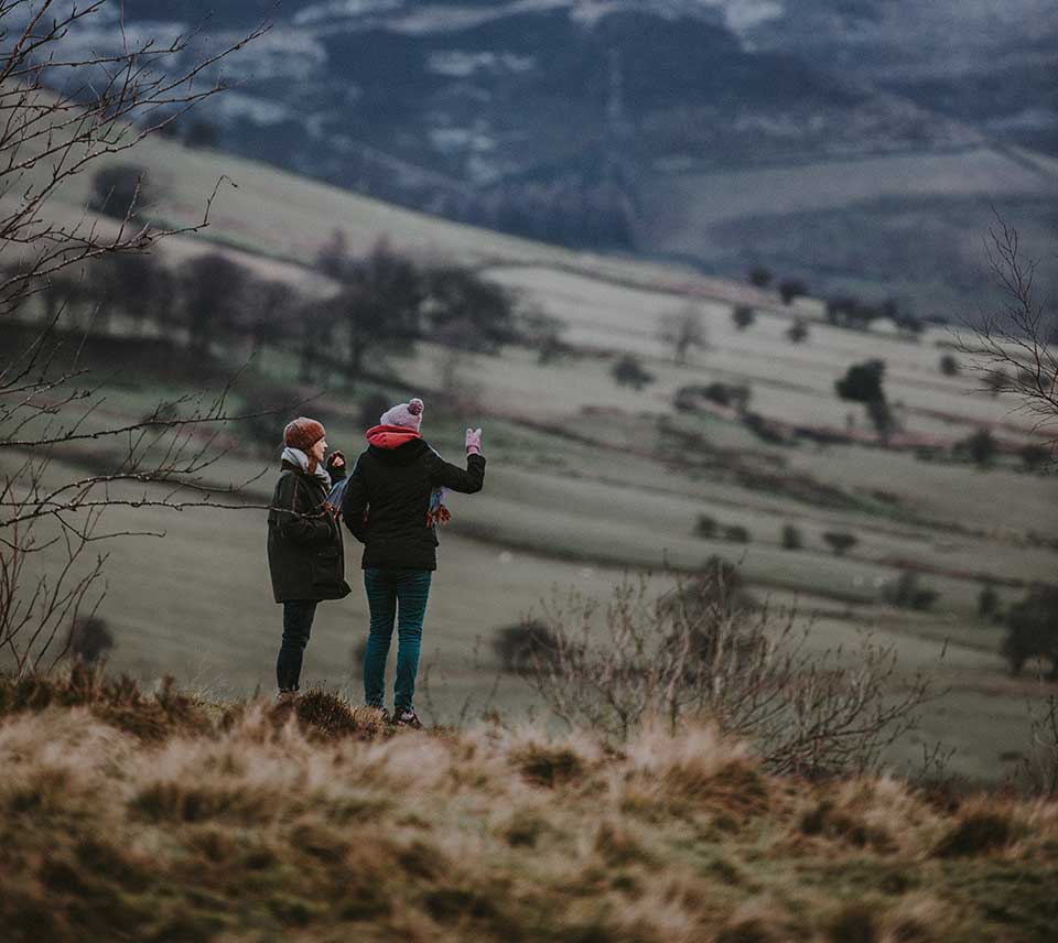 Two people standing in countryside